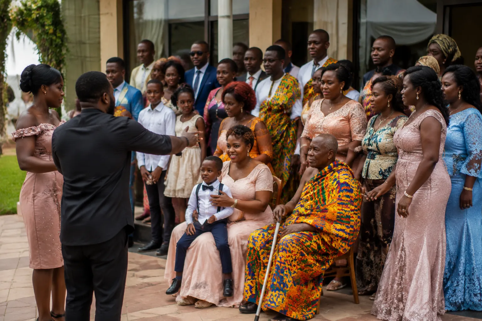 Ghanaian wedding family gathering for later photographs after a participant arrives